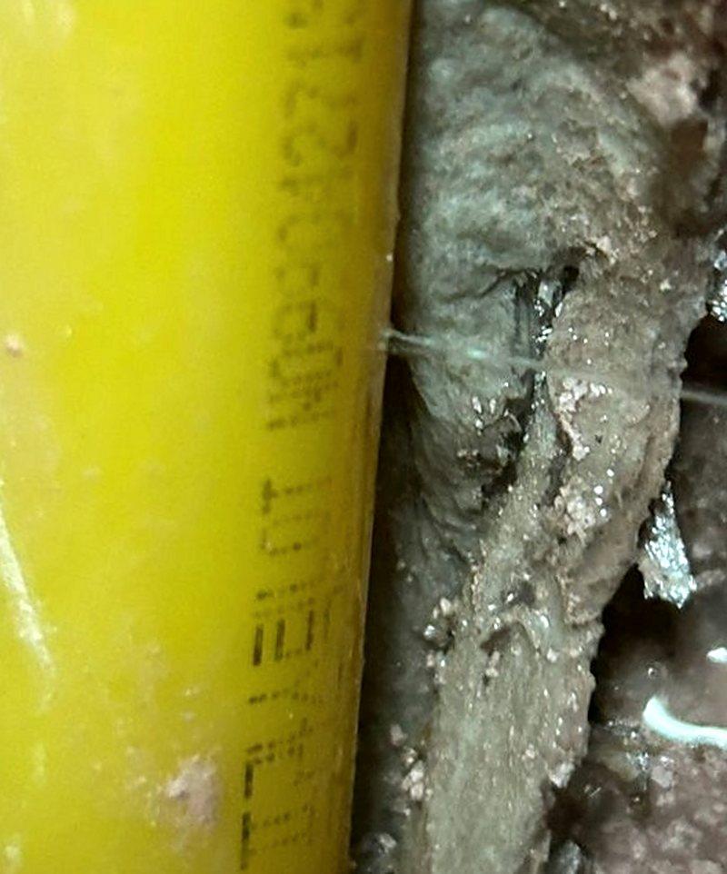 지산동 누수탐지 — 물기에 젖은 벽체 속 노란 배관 표면